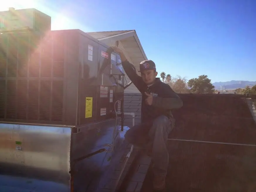 HVAC technician performing Boiler Repair on a rooftop unit in Oregon